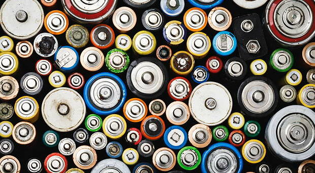 Dumped used batteries of various types (C AA AAA D 9V) collected for recycling - toxic waste and environmental issues concept